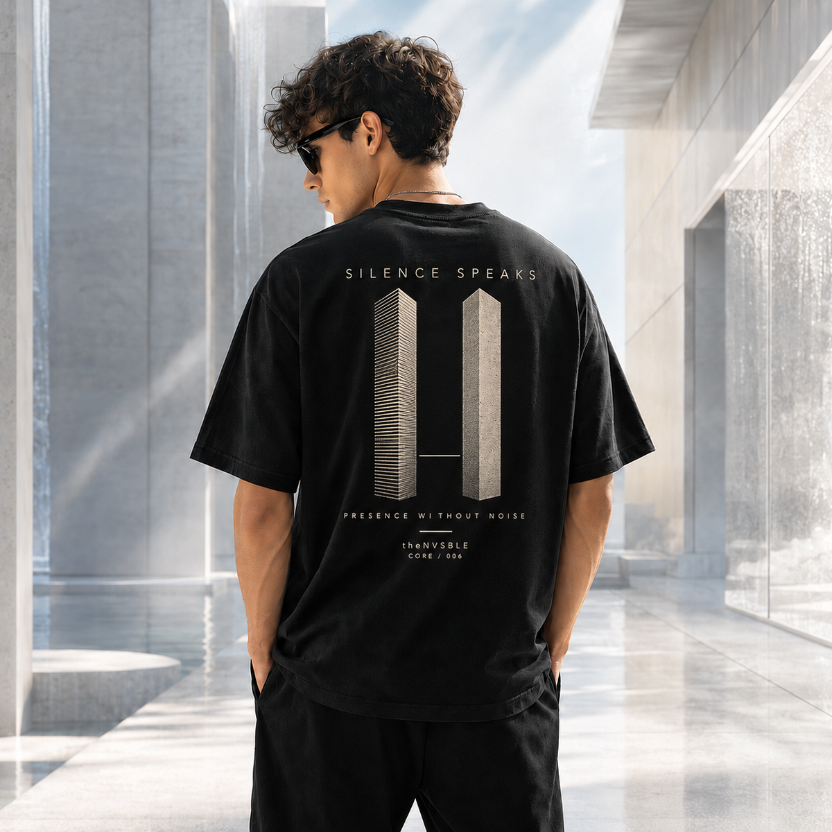 theNVSBLE CORE 006 SILENCE SPEAKS black T-shirt, back view with new architectural pause artwork